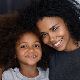 Cute funny little african american daughter with black mother bonding looking at camera, mixed race mom and child happy faces, smiling mum and kid girl posing together for headshot portrait at home