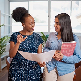 Two women discuss work solutions in boardroom office, mentorship learning. High quality photo